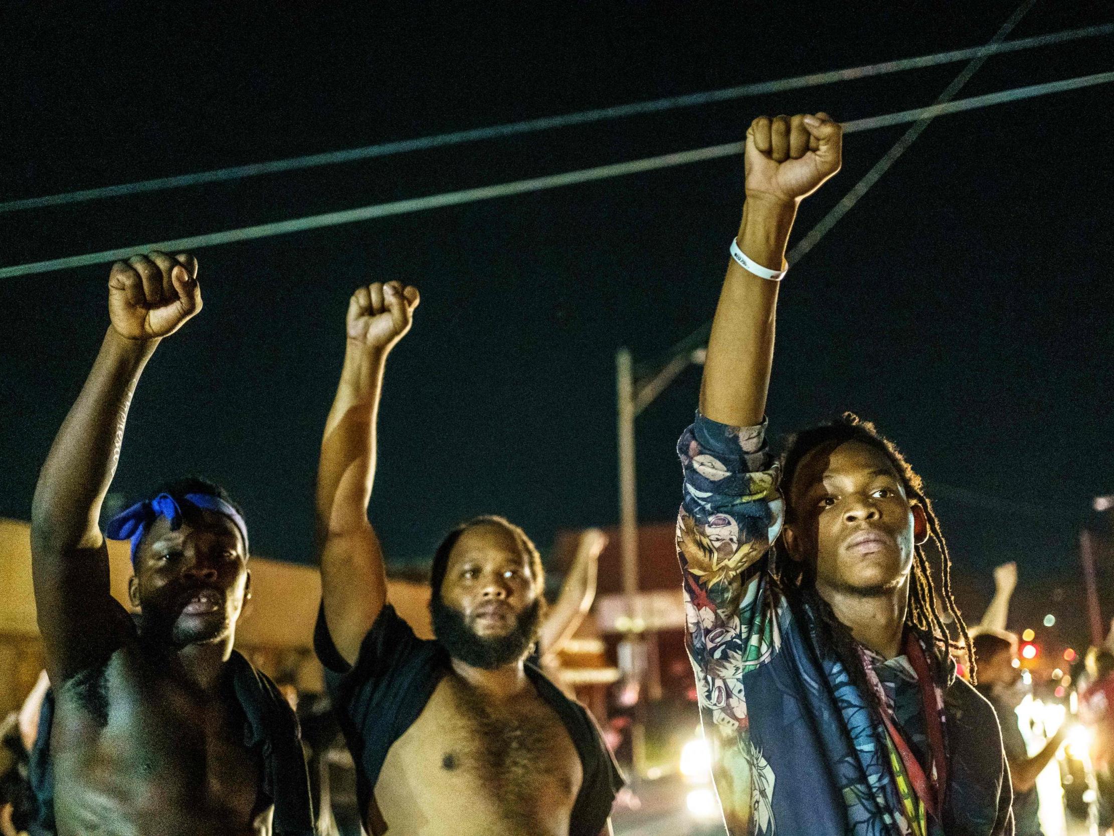 Protesters raise their fists during a demonstration against the shooting of Jacob Blake in Kenosha, Wisconsin