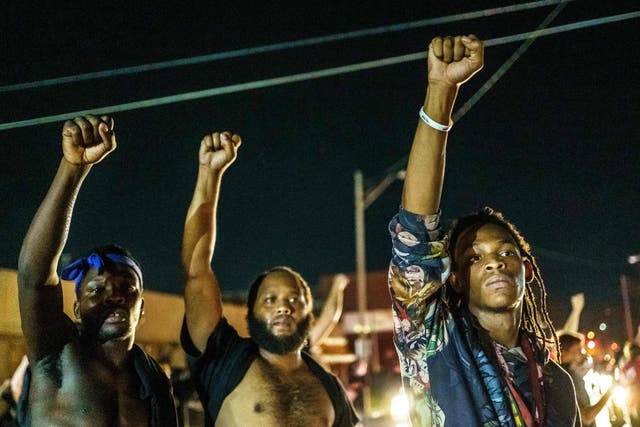 Protesters raise their fists during a demonstration against the shooting of Jacob Blake in Kenosha, Wisconsin
