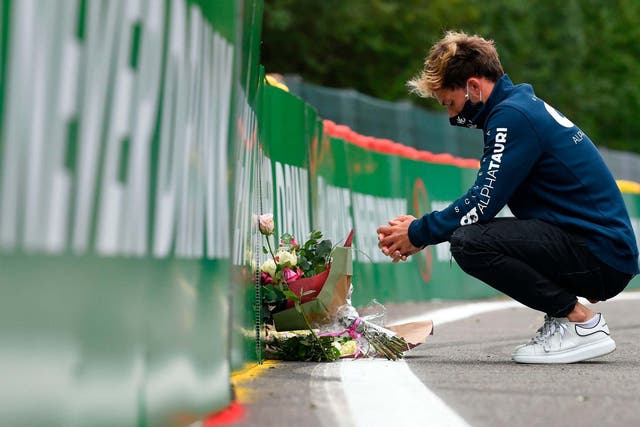 AlphaTauri's Pierre Gasly places a bouquet of flowers at the site of Anthoine Hubert's fatal accident nearly a year on