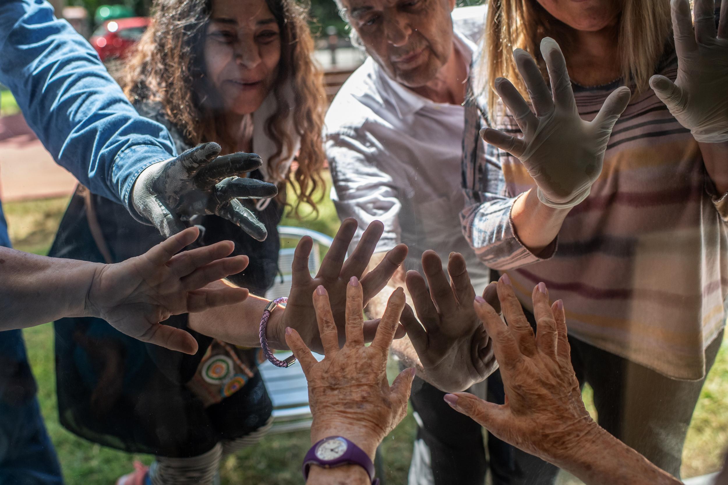 Concepcio Zendrera, 100, greets her son, daughters and relatives through a window at her nursing home near Barcelona in May