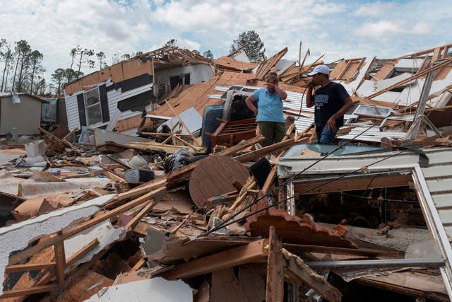 A couple react as they go through their destroyed mobile home following the passing of hurricane Laura in Lake Charles, Louisiana, on August 27, 2020