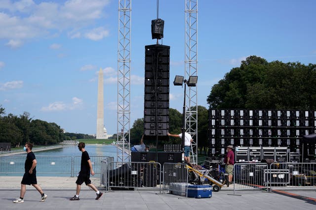 With the Washington Monument in the background, people set up equipment near the reflection pool ahead of the March on Washington, on 27 August, 2020