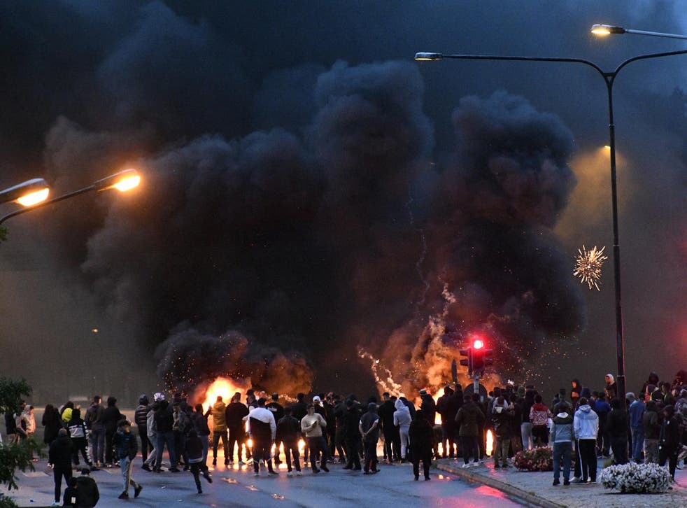 Smoke billows from burning tyres, pallets and fireworks  as hundreds protest the burning of the Quran in Malmo