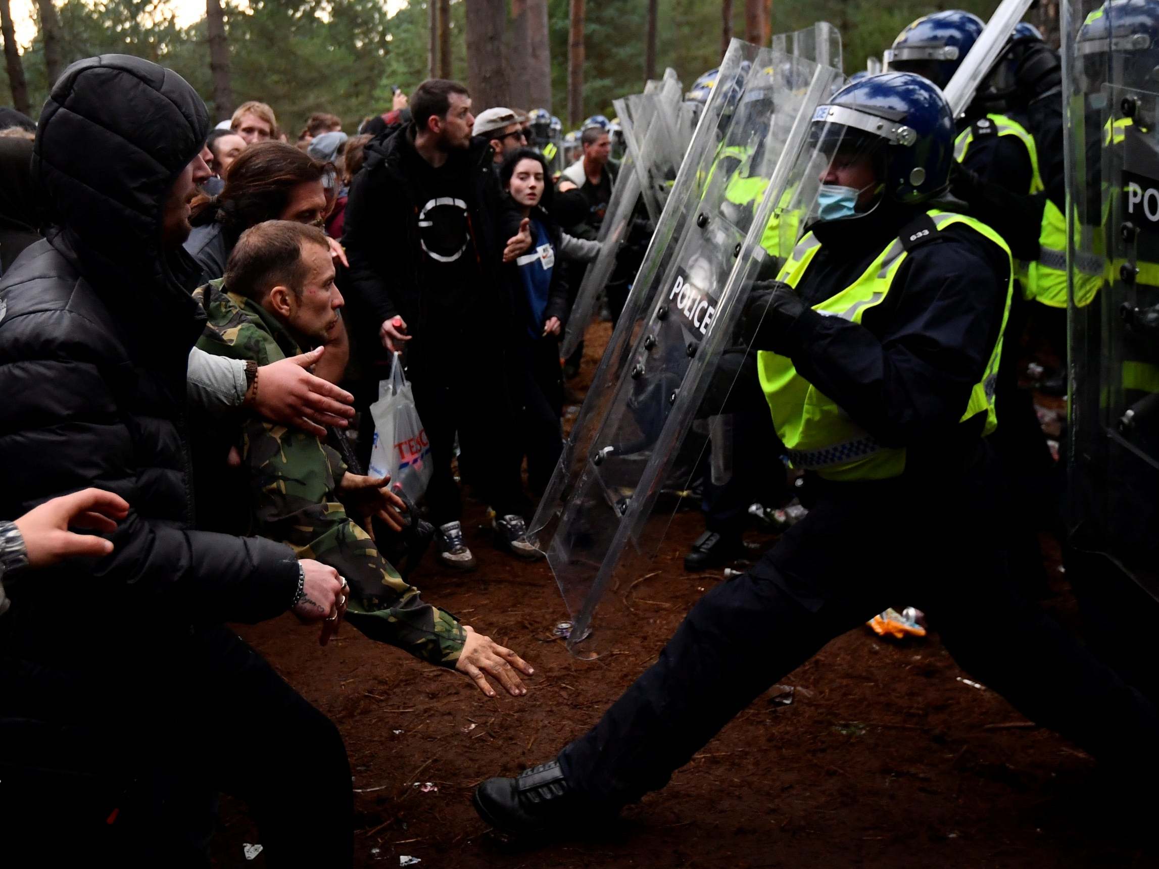 Revellers clash with riot police at the scene of a suspected illegal rave in Thetford Forest, Norfolk, 30 August 2020.