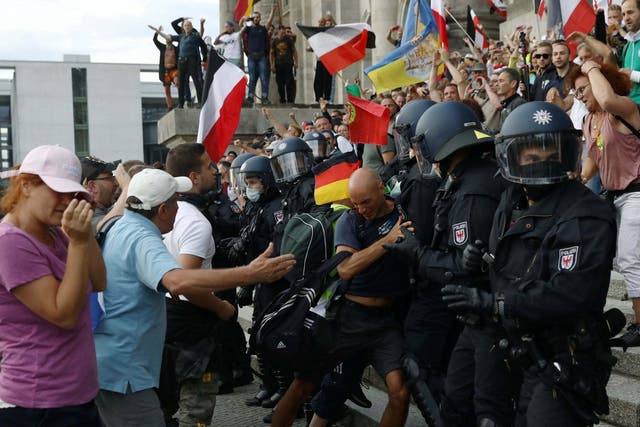 Police scuffle with protesters in front of the Reichstag building in Berlin, Germany.