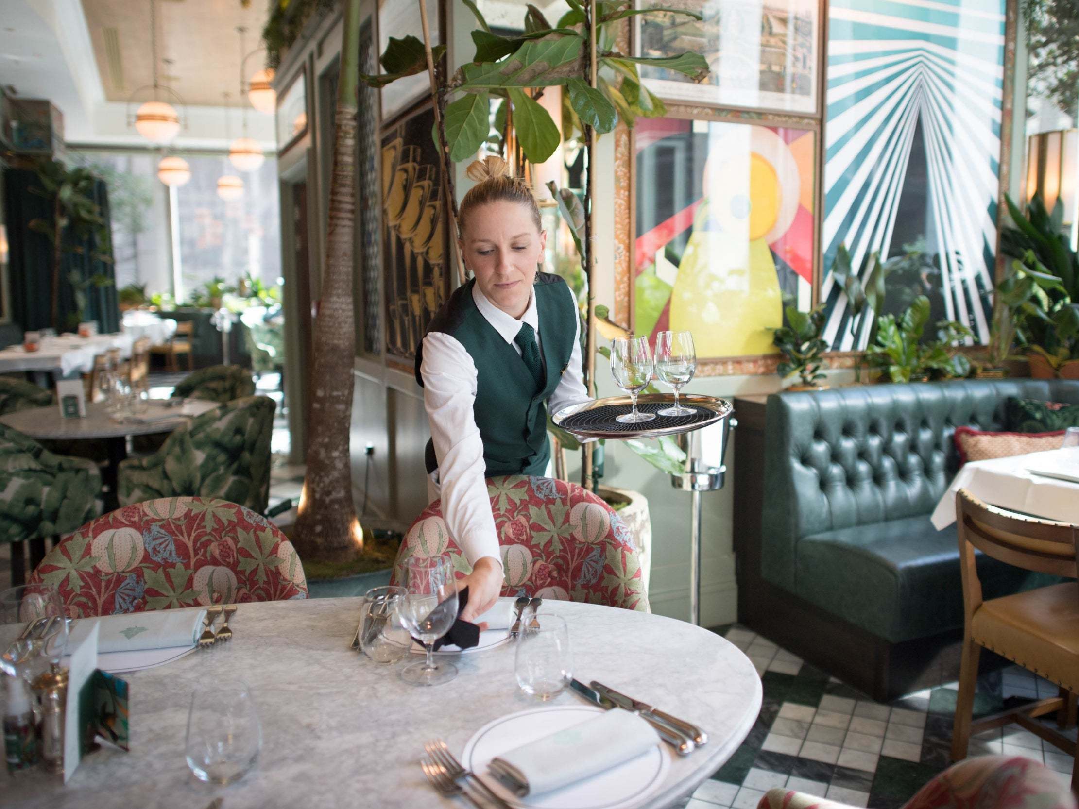 Staff at the Ivy Victoria in London, prepare the dining area, as the government initiative Eat Out to Help Out comes to an end