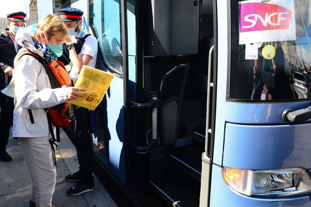 SNCF passengers board a bus in front of Bordeaux St-Jean train station in Bordeaux, southern France to reach stations further south after thousands of travellers were stranded aboard their train in the region following electrical incidents