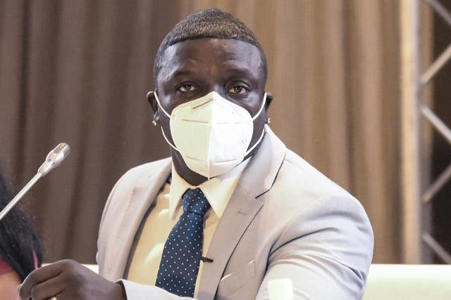 Senegalese-American singer and songwriter Akon, wearing a face mask, speaks to the press in a hotel in Dakar
