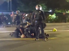 Police appear to repeatedly punch detained Portland protester who was lying in the road