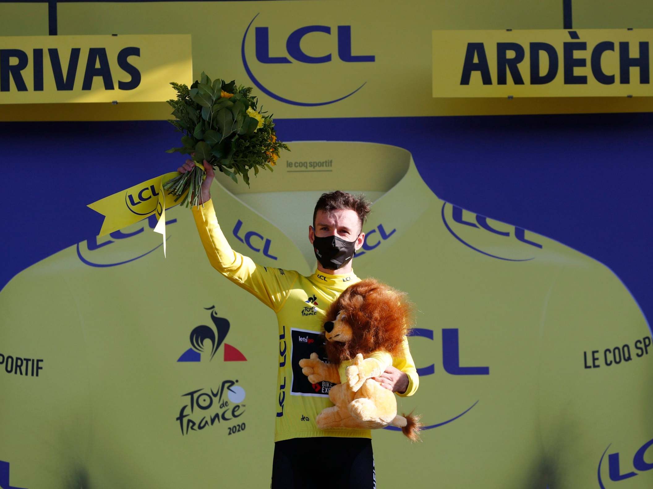 Adam Yates celebrates after earning the yellow jersey