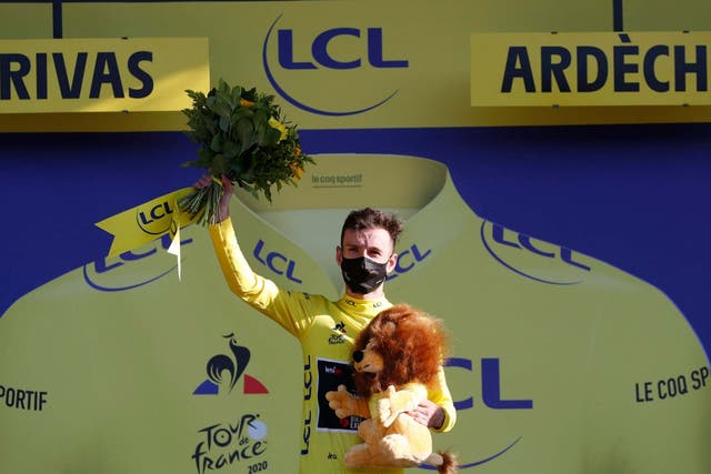 Adam Yates celebrates after earning the yellow jersey