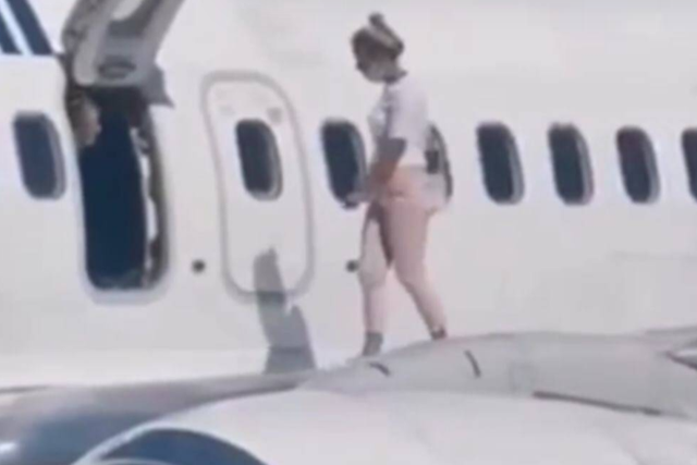 A woman hopped onto the plane wing to cool down