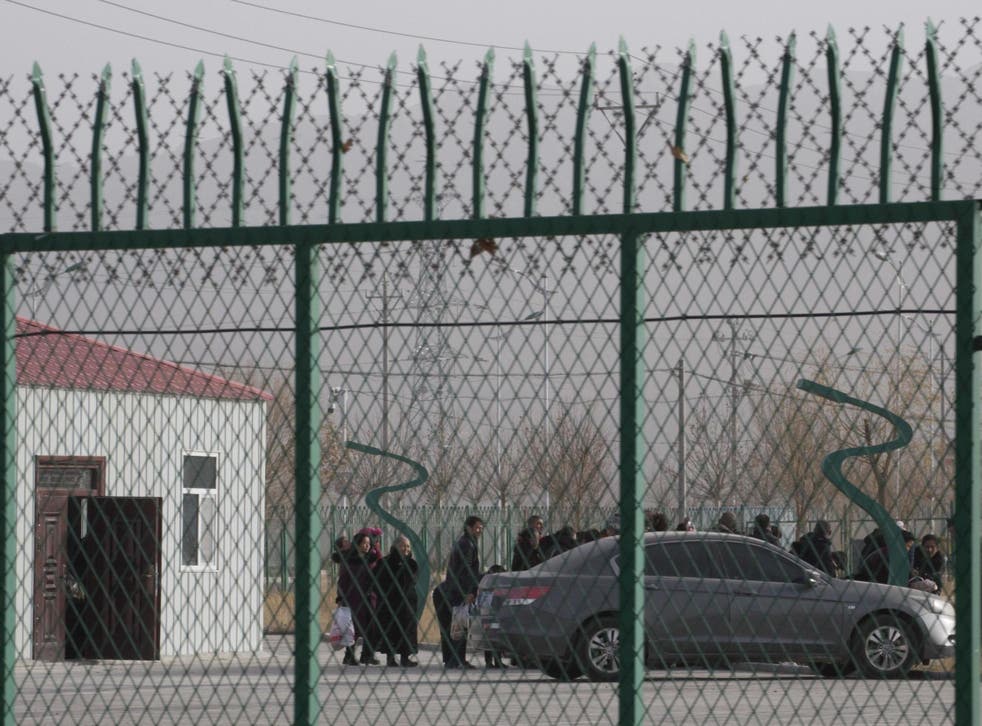 People line up at a "re-education" centre in Xinjiang province, China, in December 2018.