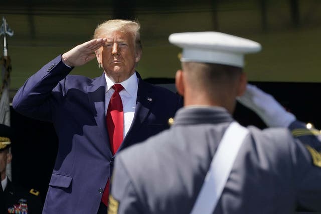 Donald Trump salutes as he arrives at West Point Military Academy