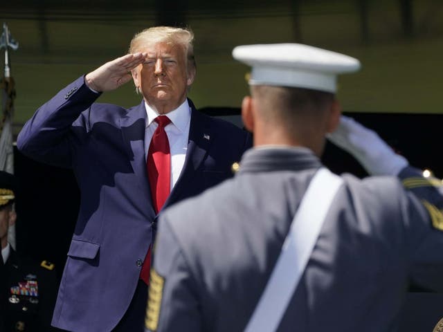 Donald Trump salutes as he arrives at West Point Military Academy