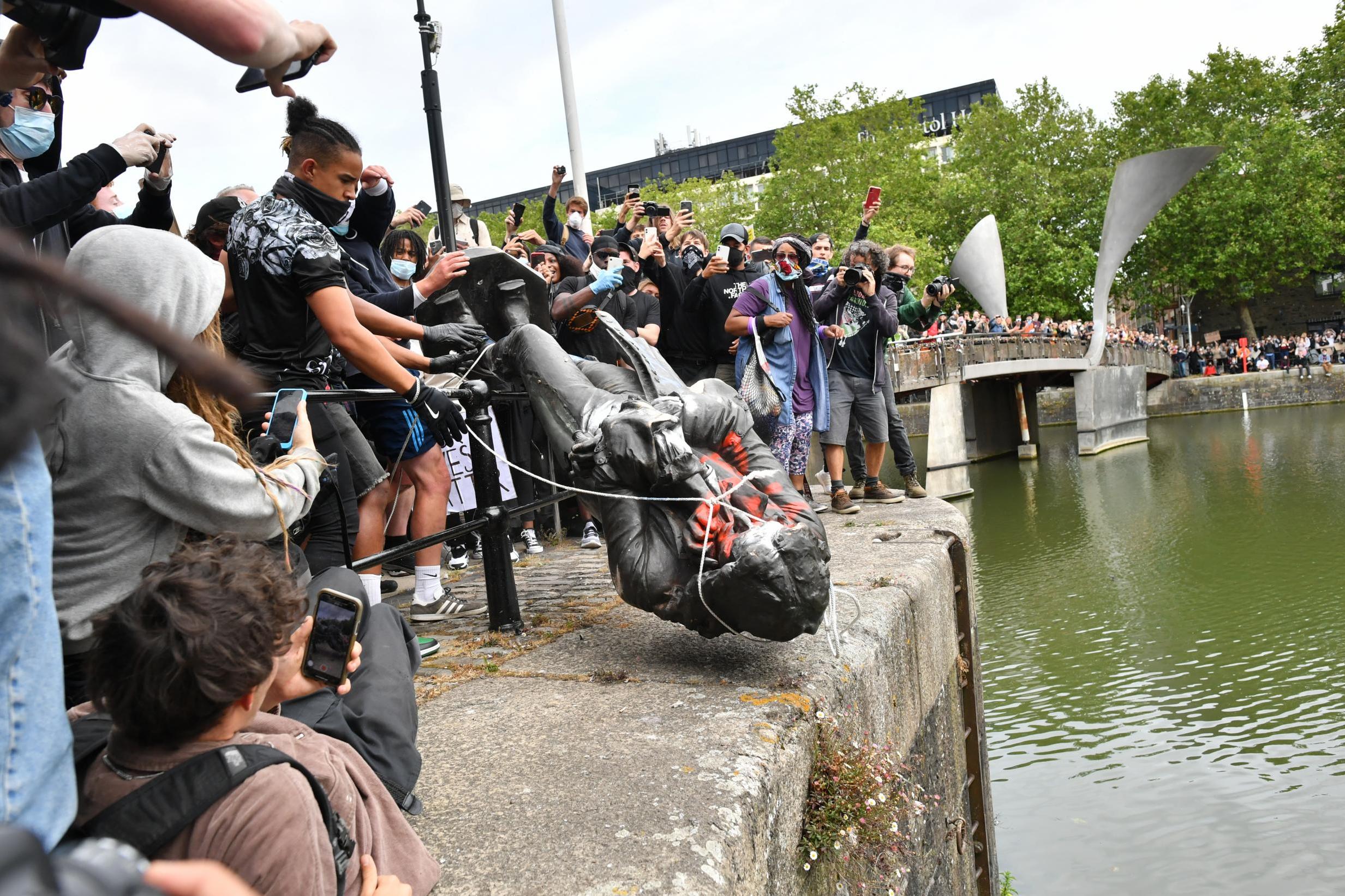 <p>Protesters throw the statue of Edward Colston into Bristol harbour</p>