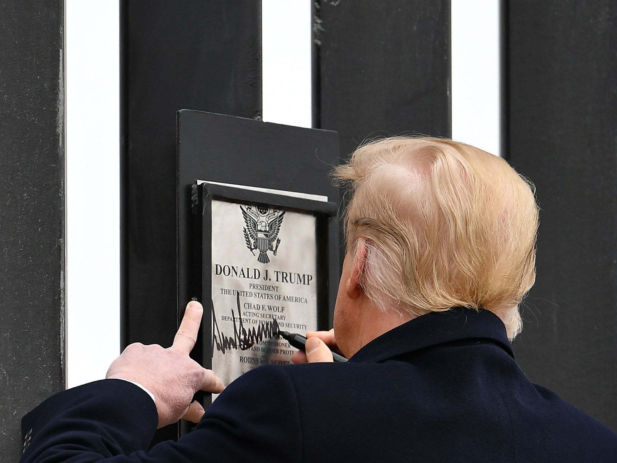 The president signs a plaque on the wall yesterday