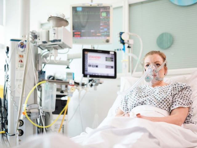 <p>A volunteer demonstrates a ‘continuous positive airway pressure’ machine, or CPAP</p>