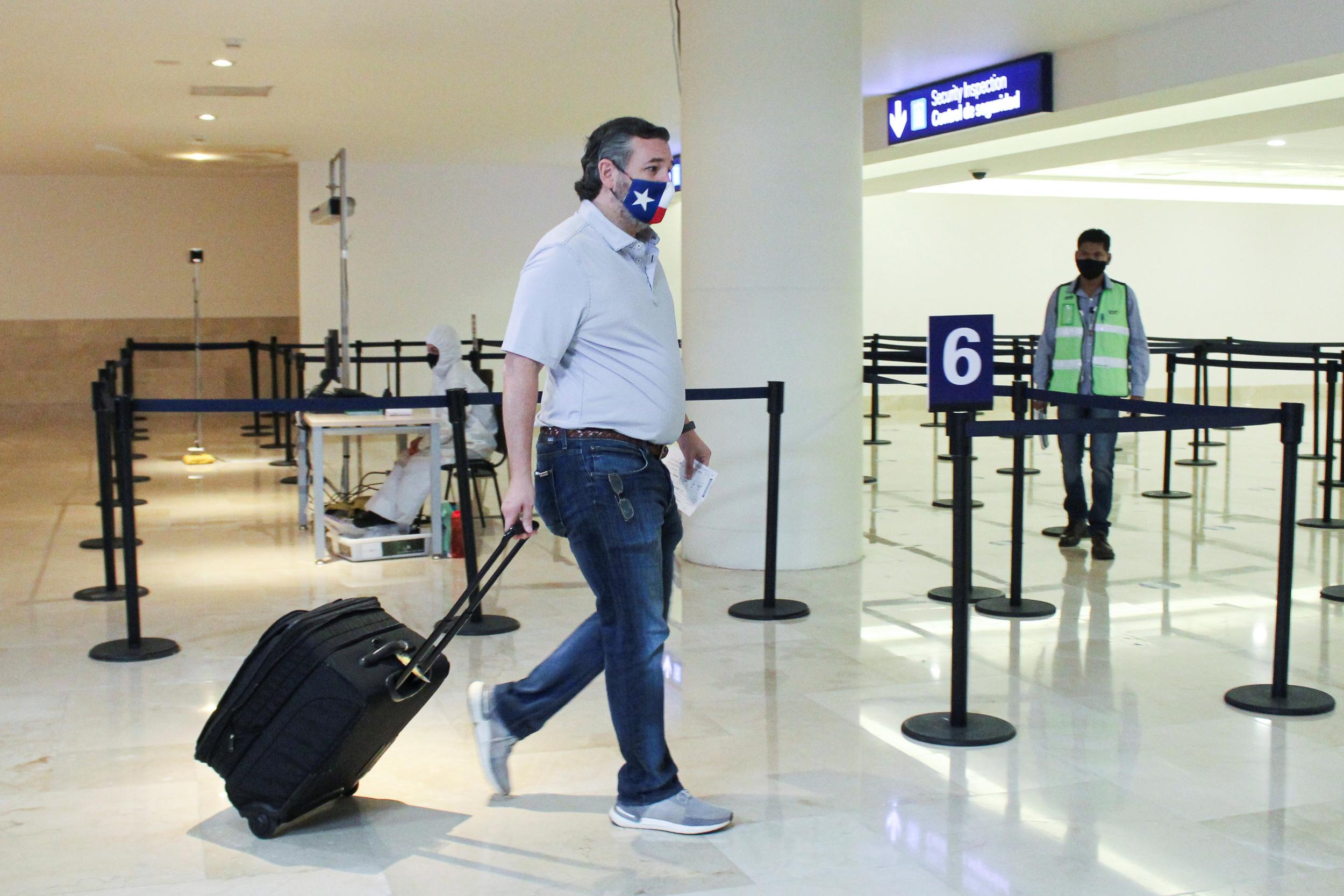 Texas Republican Senator Ted Cruz carries his luggage through Cancun International Airport before boarding his plane back to the United States on February 18 2021