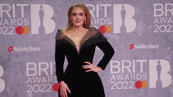 Adele poses on the red carpet as she arrives at the Brit Awards
