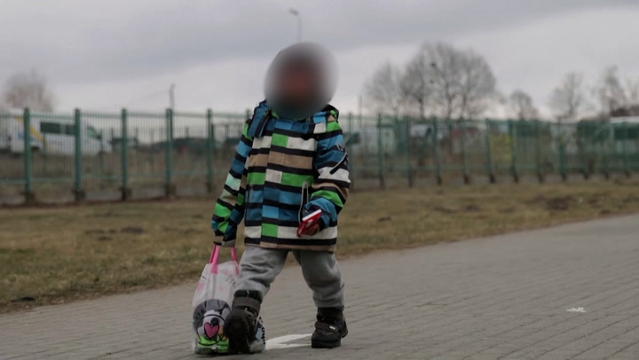 Ukrainian child cries as he arrives at Polish border after fleeing war-torn country