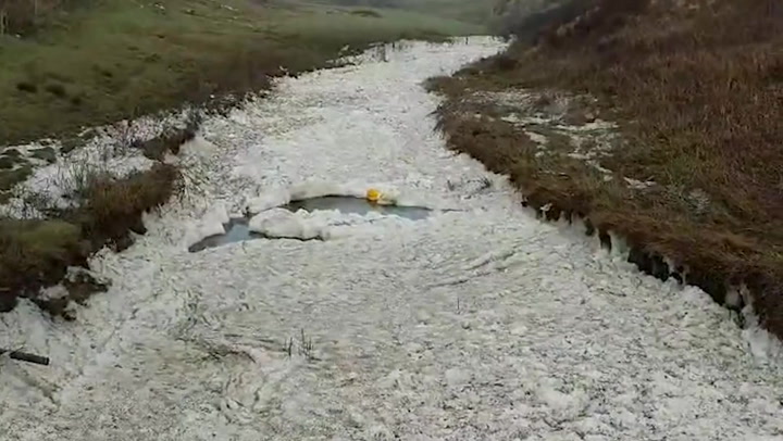 Seafoam covers stream in Ireland during Storm Franklin