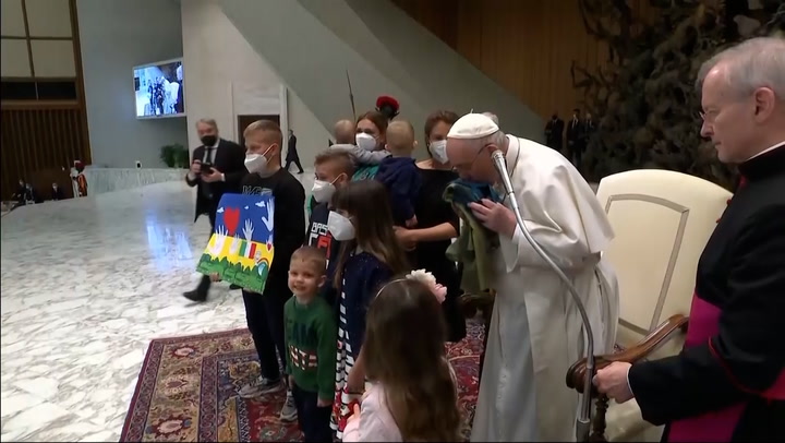 Pope kisses Ukrainian flag from Bucha as he welcomes refugees to Vatican