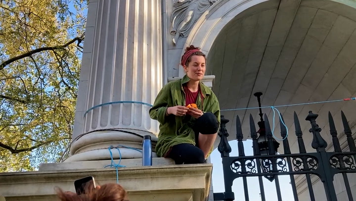Extinction Rebellion protesters scale Marble Arch to hoist a banner